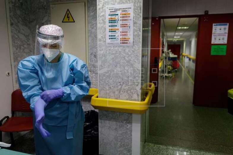 Imagen de archivo de una sanitaria vistiéndose con el equipo de protección / EFE Ramón de la Rocha